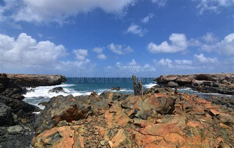 Jagged Rocks In Front Of Aruba`s Black Sand Stone Beach Stock Photo