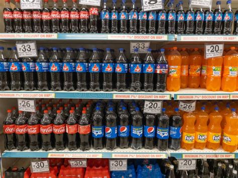 Carbonated Soft Drinks And Juices Displayed On The Shelves Of A