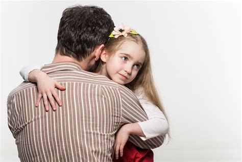 Niña Abrazando A Su Padre Sobre Un Blanco Foto Gratis