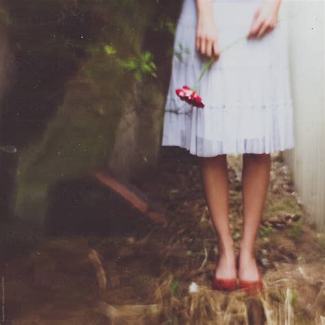 Whimsical Shot Of Woman Wearing Red Shoes And A White Skirt Holding A
