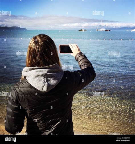 A Woman Taking A Photo Of Lake Tahoe With Her Iphone Lake Tahoe