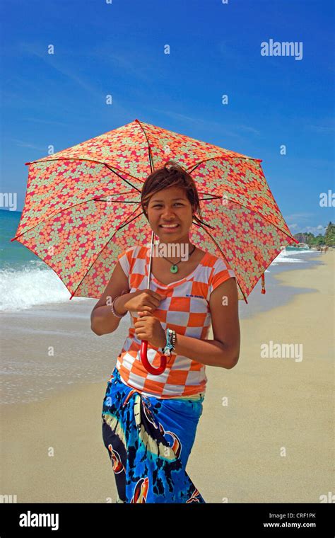 junge Mädchen zu Fuß mit einem Regenschirm auf einem Strand von Ko Samui Thailand