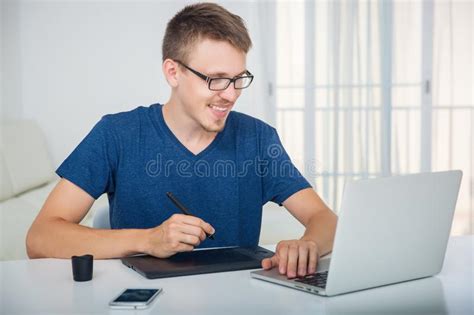 Man Working With A Graphics Tablet Behind A Laptop Stock Photo Image