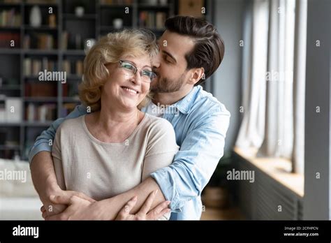 Loving Adult Son Kissing And Hugging Happy Mature Mother Stock Photo