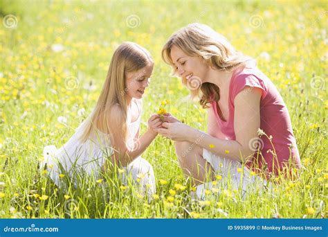 Mother And Daughter Outdoors Holding Flower Stock Image Image Of Adult Kneeling 5935899