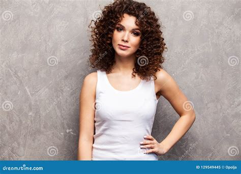 portrait of beautiful cheerful girl with flying curly hair smiling laughing looking at camera