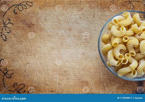 Macaroni Rigati Pasta In A Glass Cup On A Cutting Wooden Board