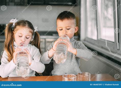 Children Girl And Boy Drink Water From Liter Bottles Very Greedily