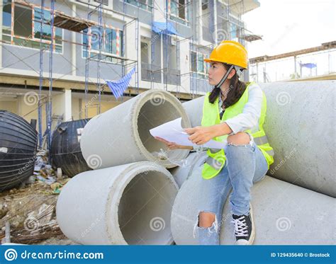 Woman Engineers Holding Blueprint At Construction Site Stock Photo