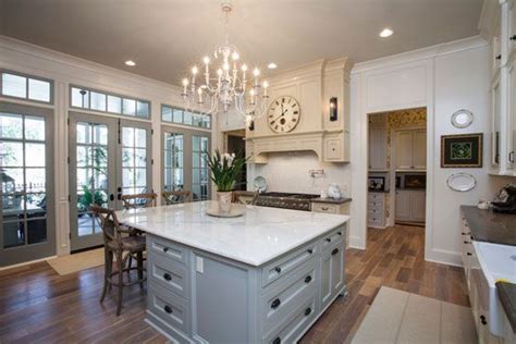 A Large Kitchen With An Island And Chandelier