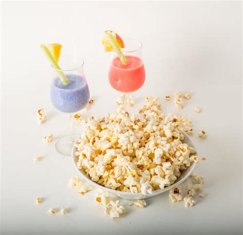Two Colorful Drinks Salty Popcorn In A Bowl And Scattered Around Stock