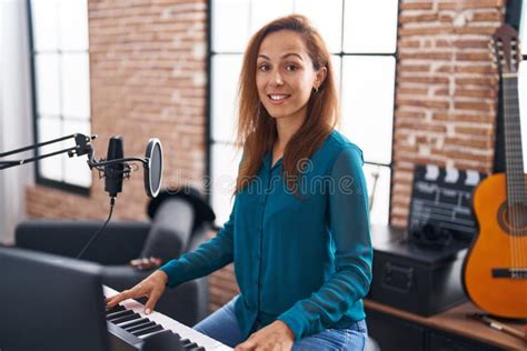 Young Woman Musician Playing Piano Keyboard At Music Studio Stock Image