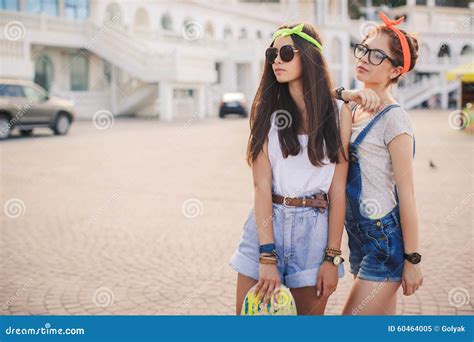 Two Beautiful Young Girls On A Skateboard In The City Stock Image