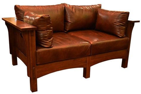 A Brown Leather Couch Sitting On Top Of A Wooden Table