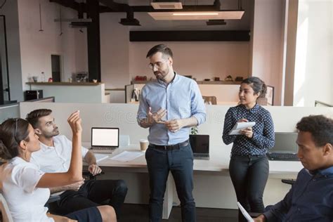 Team Leader Discuss Work Issues With Colleagues At Informal Briefing