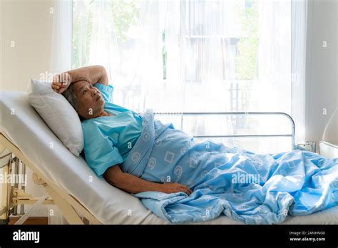 Asian Depressed Elderly Woman Patients Lying On Bed Looking Out The