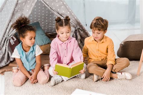 Adorable Little Children Sitting On Carpet And Stock Photo Image Of