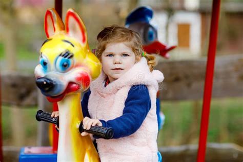 Adorable Little Toddler Girl Riding On Animal On Roundabout Carousel In