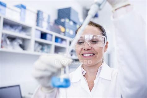 Female Laboratory Assistant Using Pipette — Caucasian Safety Stock