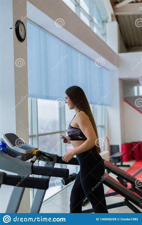 Attractive Young Sports Woman Is Working Out In Gym Doing