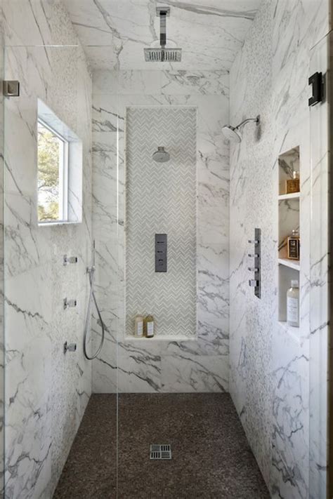 Beautifully appointed seamless glass shower is fitted with marble grid floor tiles placed beneath a marble waterfall bench fixed against large marble subway wall tiles framing a tiled niche. 32 Walk-In Shower Designs That You Will Love - DigsDigs