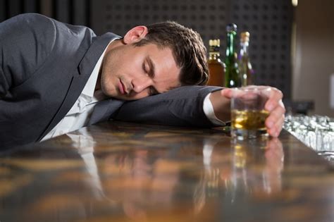 Premium Photo Drunk Man Lying On A Counter With Glass Of Whisky
