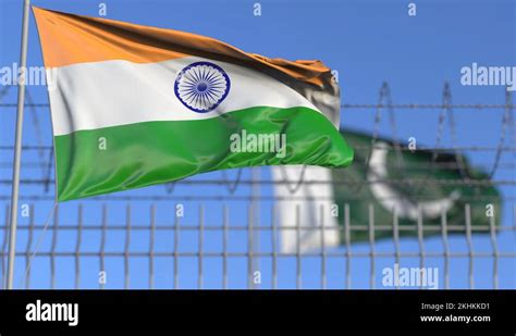 Waving Flags Of India And Pakistan Separated By Barbed Wire Fence