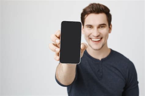 Free Photo Handsome Young Man Showing Mobile Phone Display
