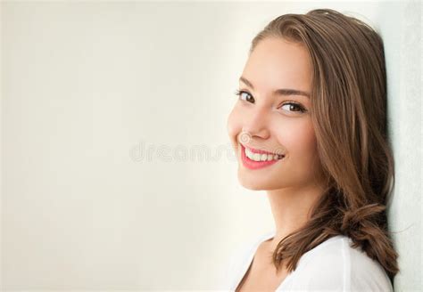 Tanned Brunette Girl In Color Swimsuit Sits On White Sandy Beach Stock