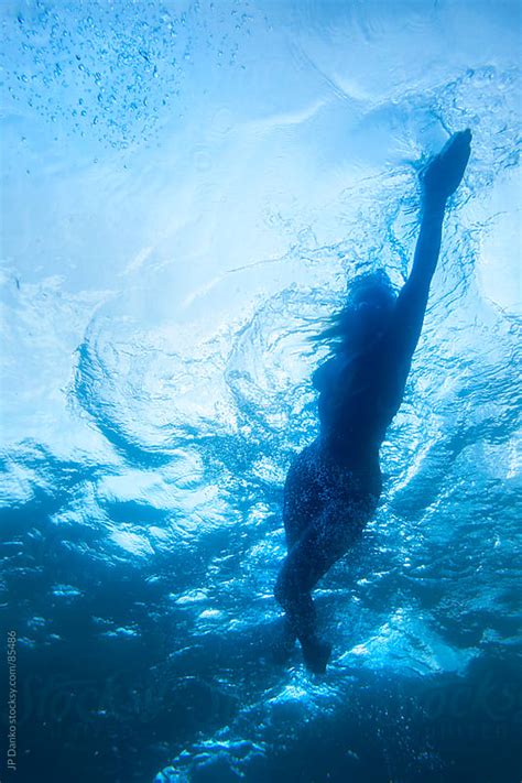 female athlete swimming underwater by jp danko stocksy united