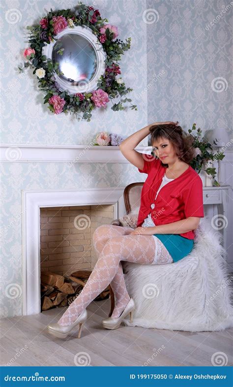 Blonde Model In White Stockings And Green Miniskirt Posing In Studio