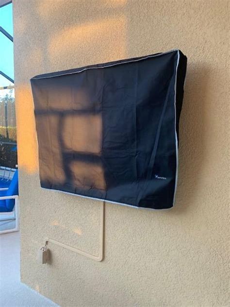 Outdoor Tv Mounted On Articulating Wall Mount And Covered With Black