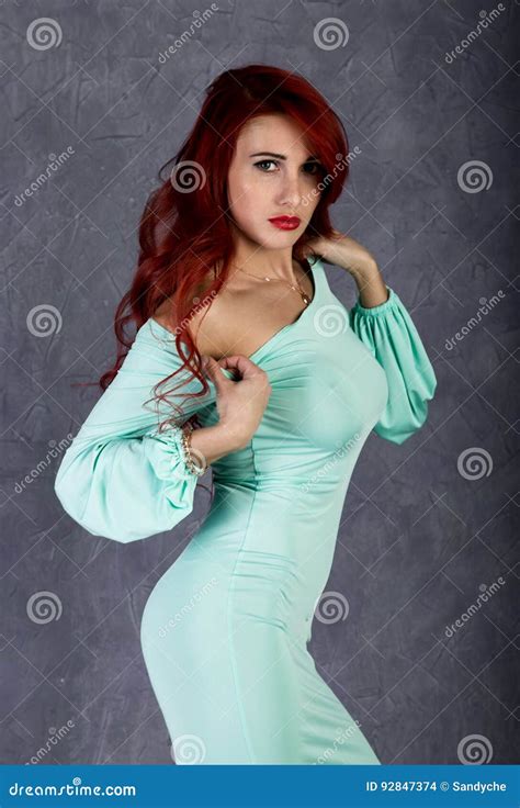Πορτρέτο της όμορφης Redhead νέας γυναίκας με τα μεγάλα Boobs σε ένα