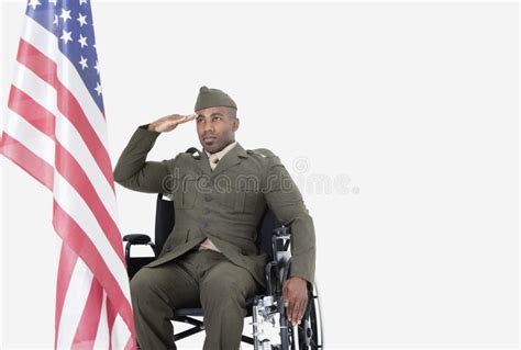 Young Us Soldier In Wheelchair Saluting American Flag Over Gray