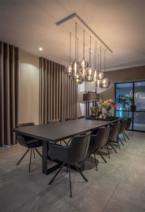 An Elegant Dining Room With Modern Lighting Fixtures