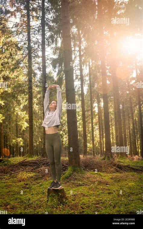 Woman Stretching Arms And Breathing Fresh Air In Middle Of A Forest