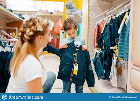 Mother With Her Boy Choosing Clothes In Kids Store Stock Image Image