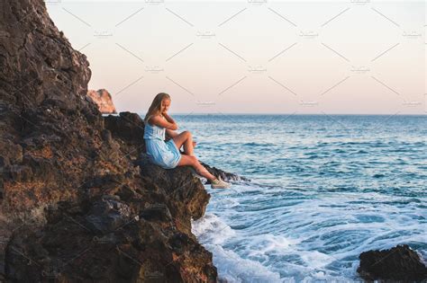 Woman Sitting On Rocks By The Sea High Quality Nature Stock Photos