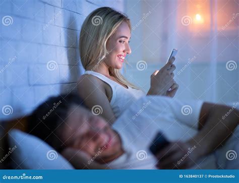 couple texting on phone lying in bed at night stock image image of husband concept 163840137