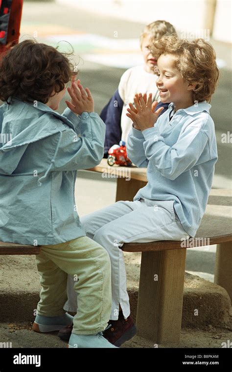 Girls Playing Clapping Game On Bench Stock Photo Alamy