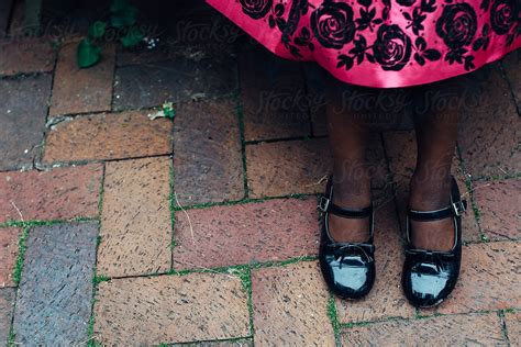 black girl s feet in patent leather shoes and pink dress by stocksy contributor gabi bucataru