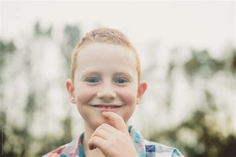 Portrait Of A Cute Young Boy Smiling In A Field By Stocksy