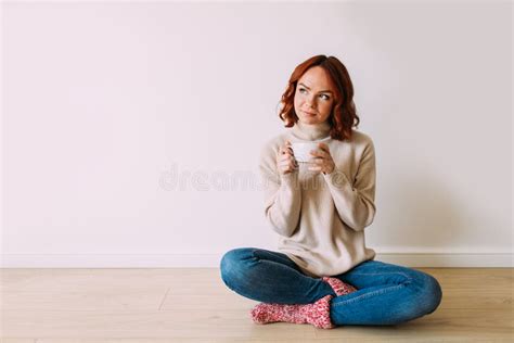 Jonge Rode Harige Vrouw Die Op De Vloer Zit Met Een Kop Koffie Stock