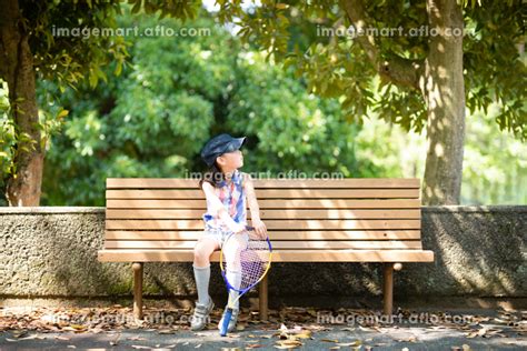 公園のベンチに座る女の子の写真素材 203375635 イメージマート