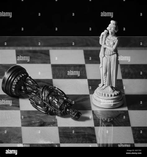 Old Chess Pieces On A Chessboard A White Queen And A Fallen Black King