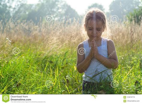 Little Girl Closed Her Eyes Praying At Sunset Hands