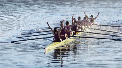 Rowing Team Celebrating In Scull On Lake