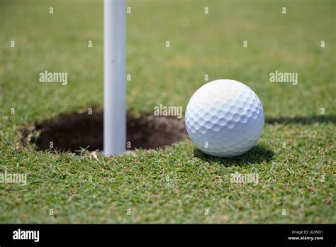 Golf Ball Near Hole Stock Photo Alamy