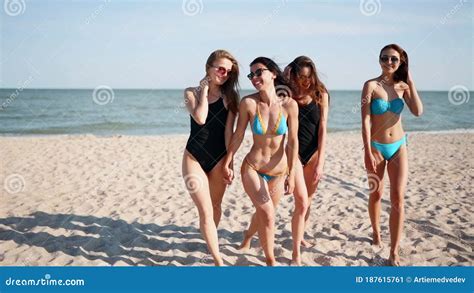 Group Of Pretty Female Friends Having Fun Walking Down Sandy Tropical Beach In Swimsuits