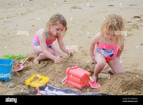 Zwei Junge Schwestern Spielen Am Strand Und Bauen Sandburgen Stockfotografie Alamy